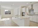 Bright, open kitchen boasts white cabinets, stainless steel appliances, and a large center island at 19015 W Rose Ln, Waddell, AZ 85355