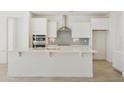 Kitchen with large island, stainless appliances, grey backsplash, and white cabinets at 19015 W Rose Ln, Waddell, AZ 85355
