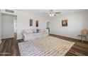 Bright living room with hardwood floors, a ceiling fan, and neutral paint, creating a versatile and welcoming space at 2204 E Birchwood Ave, Mesa, AZ 85204