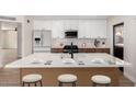 Modern kitchen with an island, white cabinets, and stainless steel appliances at 3021 W Angela Dr, Phoenix, AZ 85053
