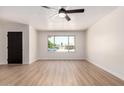 Bright, empty living room with hardwood floors, a large window, and a ceiling fan at 3021 W Angela Dr, Phoenix, AZ 85053