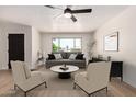 Bright living room featuring a large window, ceiling fan, and neutral decor at 3021 W Angela Dr, Phoenix, AZ 85053