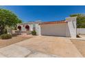 Charming single-story home with white exterior, barrel tile roof, and low-maintenance desert landscaping at 38 E Calavar Rd, Phoenix, AZ 85022