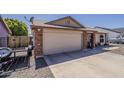 A home's two-car garage and brick pillar entryway are showcased with the long concrete driveway at 450 N 110Th St, Mesa, AZ 85207