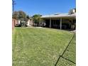 Expansive backyard featuring a lush lawn, covered patio, and ample space for outdoor activities and recreation at 4814 N 35Th St, Phoenix, AZ 85018