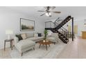 Open living room showcasing staircase, neutral furniture, and large painting at 527 N Lesueur --, Mesa, AZ 85203