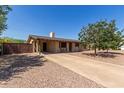 Inviting single-story home with a covered porch, a long driveway, and a low-maintenance desert landscape at 538 E Estevan Ave, Apache Junction, AZ 85119