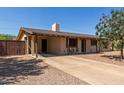 Inviting single-story home with a covered porch, a long driveway, and a low-maintenance desert landscape at 538 E Estevan Ave, Apache Junction, AZ 85119