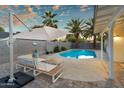 Stunning backyard featuring a refreshing pool, comfortable patio seating, and lush palm trees for a private retreat at 6201 E Waltann Ln, Scottsdale, AZ 85254