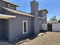 Side view of a two-story home showing the chimney and fenced yard at 121 N Brown Ave, Casa Grande, AZ 85122