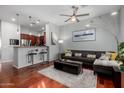 Stylish living room with hardwood floors, a comfortable gray couch, and adjacent kitchen bar seating at 121 N California St # 35, Chandler, AZ 85225