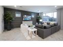 Stylish living room featuring a dark accent wall, chic furniture, and large windows at 13195 N 145Th Ln, Surprise, AZ 85379
