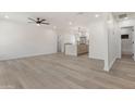 Open-concept living area showcasing hardwood floors, white walls, and a seamless transition into the kitchen and bathroom at 1367 E Mitchell Dr, Phoenix, AZ 85014