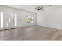 Bright living room featuring hardwood floors, a modern ceiling fan, and a view of the front yard at 1367 E Mitchell Dr, Phoenix, AZ 85014