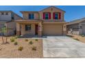 Charming two-story home featuring a two-car garage, red shutters, and desert landscaping at 18351 W Patrick Ln, Surprise, AZ 85387
