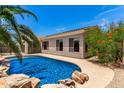 A pristine pool in a private backyard, surrounded by a rock border and lush greenery, perfect for outdoor enjoyment at 1865 E Locust Pl, Chandler, AZ 85286