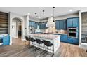 Elegant kitchen with blue cabinets, stainless appliances, granite countertops, and a large island with seating at 24695 S 195Th Way, Queen Creek, AZ 85142
