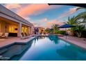 A serene outdoor pool setting with covered seating and manicured landscaping at 24695 S 195Th Way, Queen Creek, AZ 85142