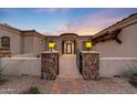 Elegant front entrance boasts stone pillars and an iron gate leading to the front door at 26204 S Washington St, Chandler, AZ 85249