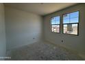 A bedroom with 2 windows is shown at 46868 W Old Timer Rd, Maricopa, AZ 85139