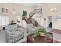 Spacious living room with a grand staircase, high ceilings, and lots of natural light at 6376 W Louise Dr, Glendale, AZ 85310