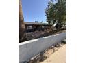 Charming single-story home with desert landscaping, block wall, and mature trees, providing shade at 6429 W Palm Ln, Phoenix, AZ 85035
