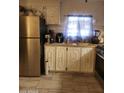 Charming kitchen featuring stainless steel refrigerator, white cabinetry, and tile floors at 6733 W Sherri Jean Ln, Peoria, AZ 85382