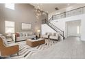 Bright living room featuring a stairway, modern chandelier, neutral furniture, and a decorative rug at 694 W Desert Seasons Dr, San Tan Valley, AZ 85143