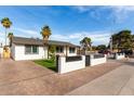 Stylish white home featuring well-maintained landscaping, a privacy fence, and a covered patio perfect for entertaining at 7502 W Cora Ln, Phoenix, AZ 85033