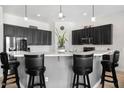 Eat-in kitchen featuring black cabinets, stainless steel appliances and seating for three at 9545 E Gary St, Mesa, AZ 85207