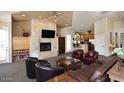A spacious living room with a fireplace, TV and leather furniture at 11375 E Sahuaro Dr # 2064, Scottsdale, AZ 85259