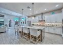 Open-concept kitchen boasts a large center island with seating, stainless steel appliances, and stylish pendant lighting at 13162 W Golden Puma Trl, Peoria, AZ 85383