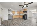 Open kitchen with wood cabinets, stainless steel appliances, and modern gray flooring at 1427 W 6Th Dr, Mesa, AZ 85202
