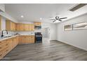 Bright kitchen featuring wood cabinetry, modern appliances, and spacious gray laminate flooring at 1427 W 6Th Dr, Mesa, AZ 85202