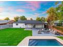 Aerial view of backyard with pool, lush lawn, patio area, and surrounding greenery at 1535 W Berridge Ln, Phoenix, AZ 85015