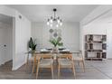 Stylish dining room featuring a glass table, modern lighting, and tasteful decor at 1561 N Sterling St, Mesa, AZ 85207