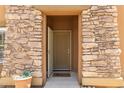 Inviting front entrance with a stone-framed doorway and a welcoming 'OH HELLO' doormat at 19700 N 76Th St # 1040, Scottsdale, AZ 85255