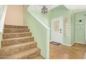 Inviting entryway with tiled floor, decorative front door and view of the carpeted staircase at 1991 S Bahama Dr, Gilbert, AZ 85295