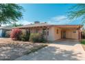 This single-story home offers a convenient carport, desert landscaping, and a welcoming facade at 2002 W Whitton Ave, Phoenix, AZ 85015