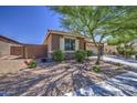 Side view of the house shows brick wall with colorful flowers with a well-manicured lawn at 23781 W Mohave St, Buckeye, AZ 85326