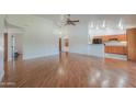 Spacious living room with hardwood floors, ceiling fan, and open layout to the kitchen and front entry at 238 W Myrna Ln, Tempe, AZ 85284
