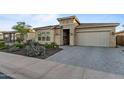 Inviting house featuring a stone facade, desert landscaping, and a brick driveway at 31210 N 122Nd Ln, Peoria, AZ 85383