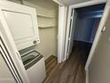 Convenient laundry area features a stacked washer and dryer with storage shelves at 3434 W Danbury Dr # A206, Phoenix, AZ 85053
