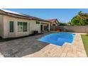 Backyard view showcasing the pool with stone surround and mature landscaping at 3685 N 141St Dr, Goodyear, AZ 85395