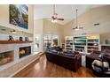 Open living space featuring a fireplace, built-in shelving, hardwood floors, and high vaulted ceilings at 4136 E Greenway Cir, Mesa, AZ 85205