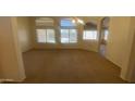 Spacious living room with carpet floors and multiple windows for natural light at 5374 N Ormondo Way, Litchfield Park, AZ 85340