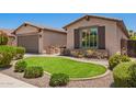 Well maintained home with tidy green lawn and desert landscaping elements at 595 W Dragon Tree Ave, Queen Creek, AZ 85140