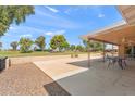 Large backyard with a covered patio, hardscape area, and lush landscaping overlooking a golf course at 636 S Rosemont --, Mesa, AZ 85206