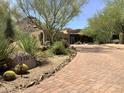 Beautiful home featuring desert landscaping, stone details, and a private drive at 7731 E Soaring Eagle Way, Scottsdale, AZ 85266