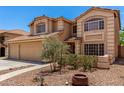 Warm toned, two-story home featuring a two-car garage and desert landscaping at 82 N 221St Ave, Buckeye, AZ 85326
